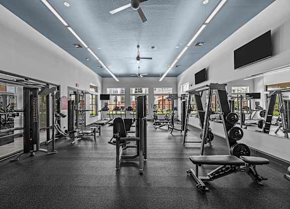 A gym with a variety of equipment including weights and machines.