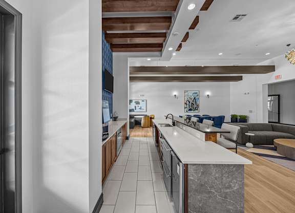 A modern kitchen with a marble countertop and wooden cabinets.