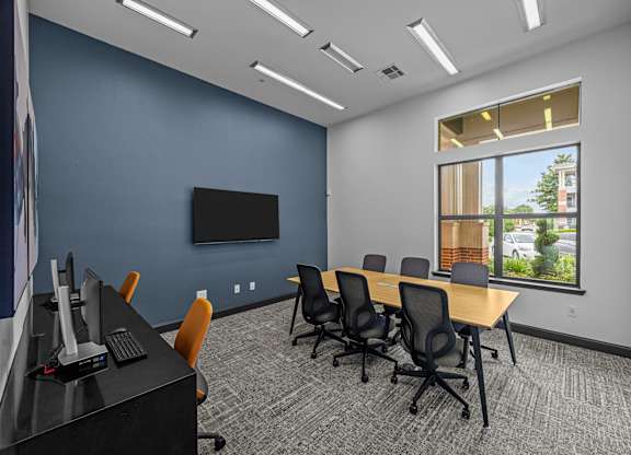 A conference room with a long table and chairs.