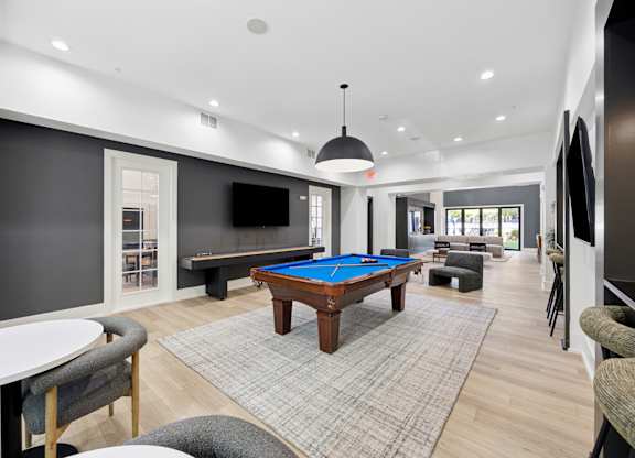 A room with a pool table and a television.