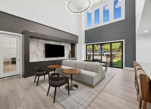 A modern living room with a grey sofa, a round table, and a television.