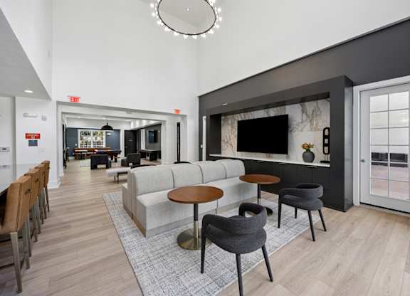 A modern living room with a grey couch, a coffee table, and a TV.
