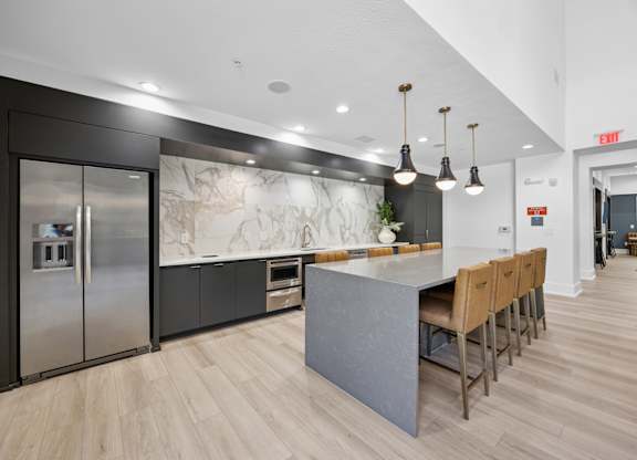 A kitchen with a marble backsplash and wooden floors.