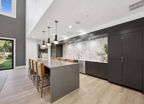 A modern kitchen with a marble backsplash and wooden floors.