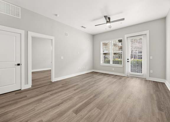A room with a ceiling fan and a window with blinds.