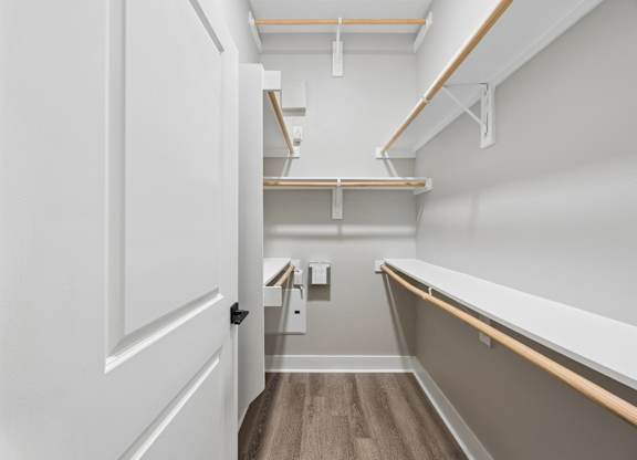 A white door is open to a hallway with a bench and shelves.