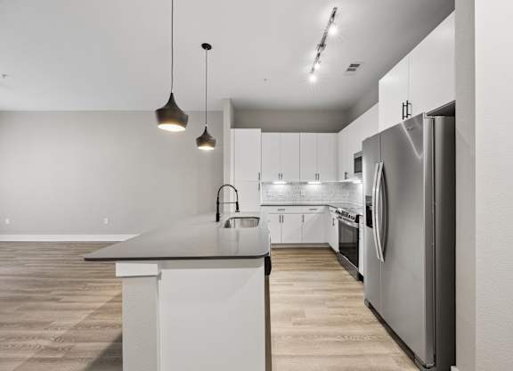 A modern kitchen with a large island and stainless steel appliances.