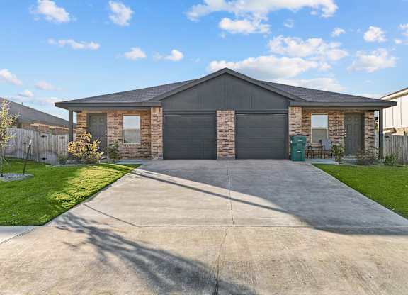 the front of a house with a driveway and grass