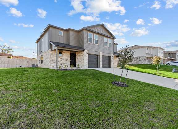 a house with a driveway and a lawn in front of it