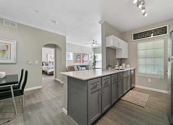 a kitchen with a large island and a dining room in the background