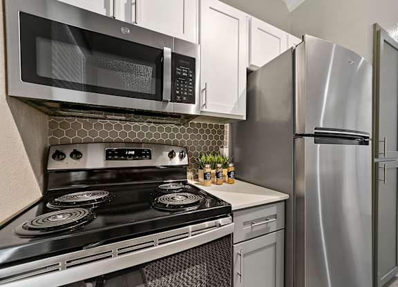a kitchen with white cabinets and stainless steel appliances