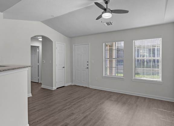 an empty kitchen and living room with a ceiling fan