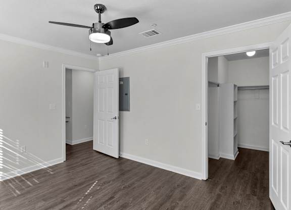 an empty room with white walls and a ceiling fan