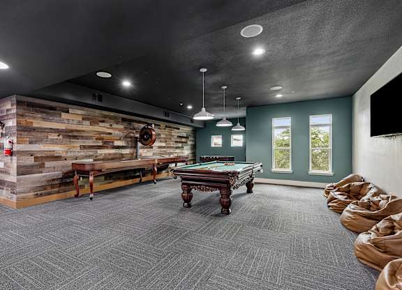 A room with a pool table and a wooden wall.