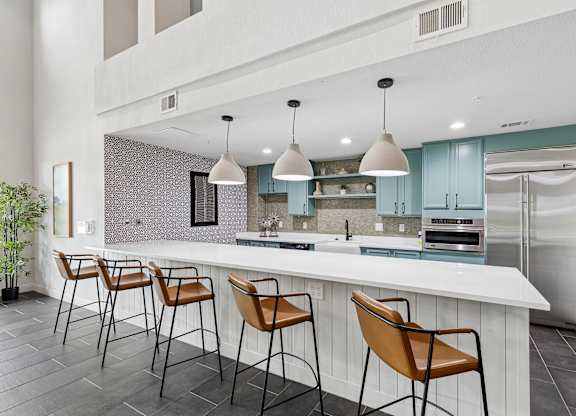 A kitchen with a white counter and brown chairs.