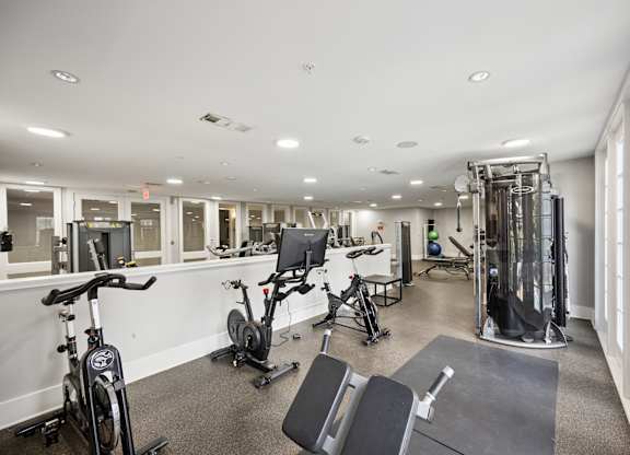 A spacious gym with a variety of equipment including treadmills, stationary bikes, and weight machines.