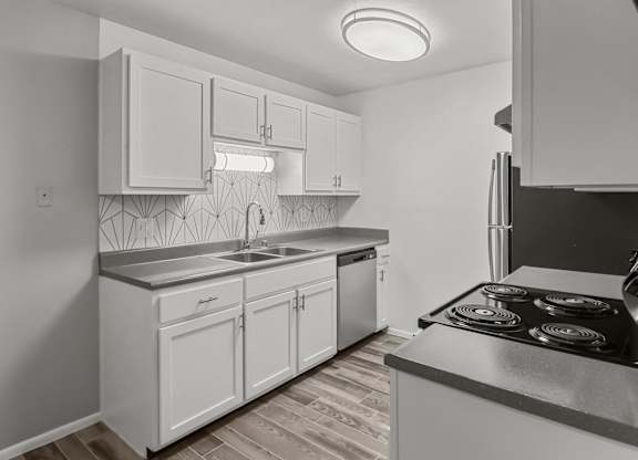an empty kitchen with white cabinets and stainless steel appliances