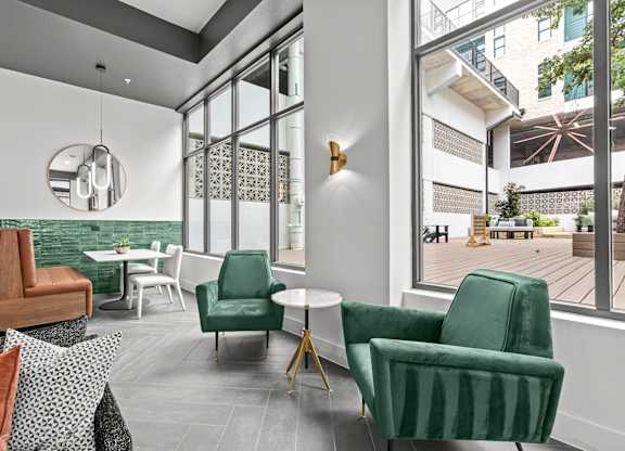 A living room with a green chair and a white table.