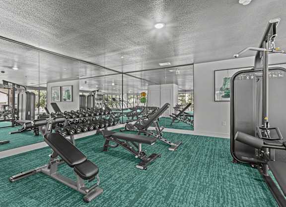 A gym with a variety of equipment including a leg press machine.