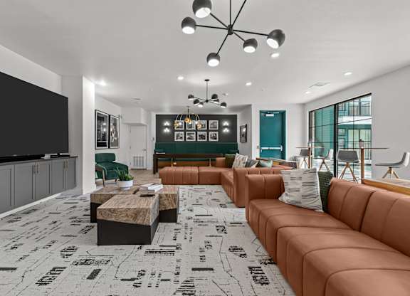 A living room with a brown sofa and a black and white floor.