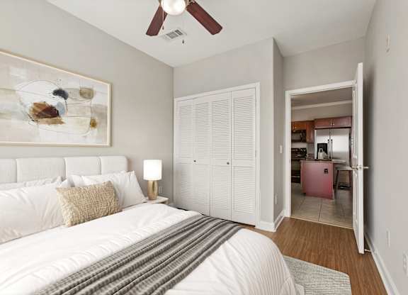 A bedroom with a large bed and a painting on the wall.