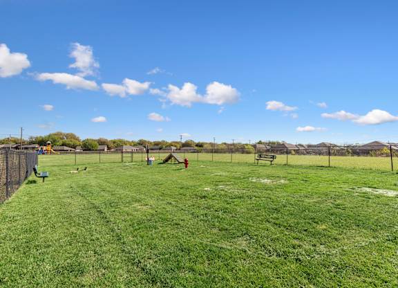 A park with a blue sky and white clouds.