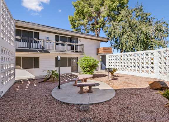 A patio area with a table and chairs in front of a building.
