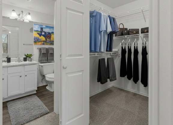A white door is open to a bathroom with a toilet and sink.