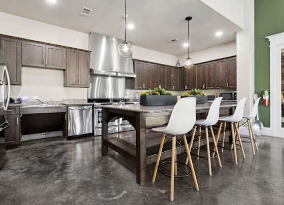 A modern kitchen with a large island and stainless steel appliances.