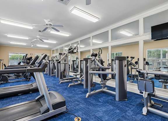 A spacious gym with treadmills, elliptical machines, and other exercise equipment.