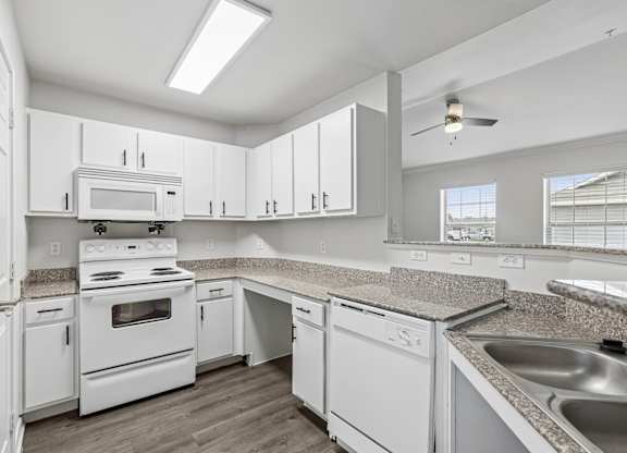 A kitchen with white appliances and cabinets.
