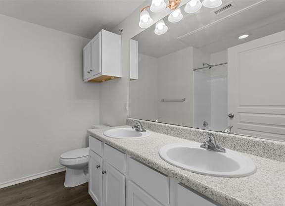 A white bathroom with a toilet, sink, and medicine cabinet.