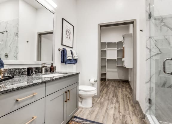 a bathroom with a shower and a sink and a toilet
