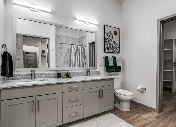 a bathroom with a large mirror and a toilet and a sink
