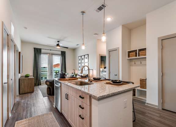 A modern kitchen with a large island and pendant lights.