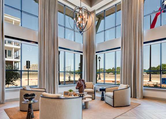 A large, modern living room with a high ceiling and a large chandelier.
