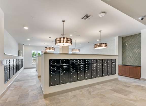 A long hallway with a row of mailboxes on the wall.