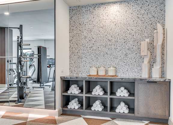 A bathroom with a tiled floor and a wall with a speckled pattern.