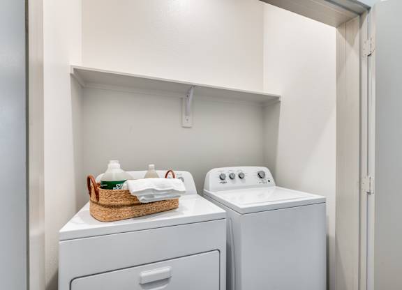 A laundry room with a basket of clean clothes on top of a washing machine.