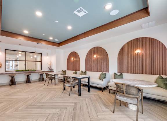 A modern living room with a wooden floor and white furniture.