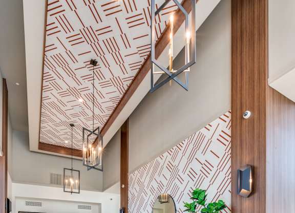 A living room with a patterned wallpaper and a wooden ceiling.