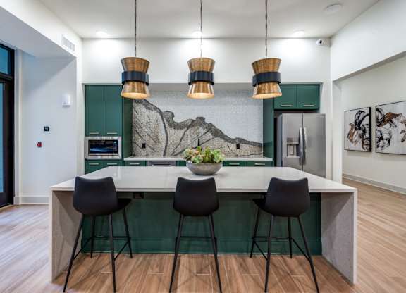 A kitchen with a bar and chairs.