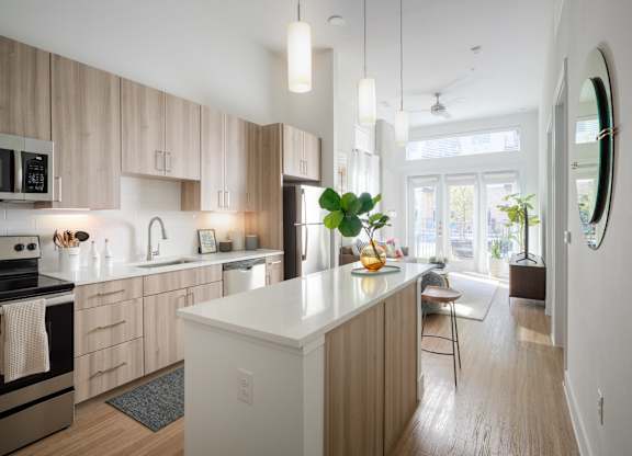 A modern kitchen with wooden cabinets and a white island.