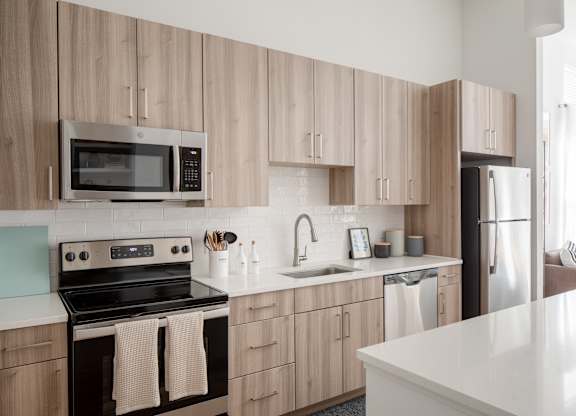 A kitchen with wooden cabinets and a black stove top oven.
