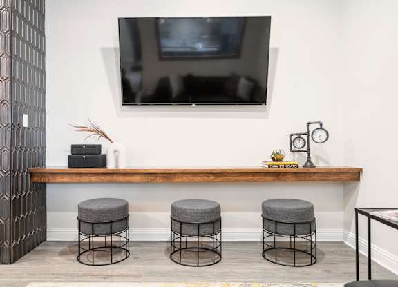 a room with a television and three stools