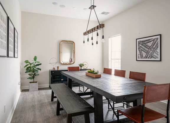 A dining room with a wooden table and chairs.