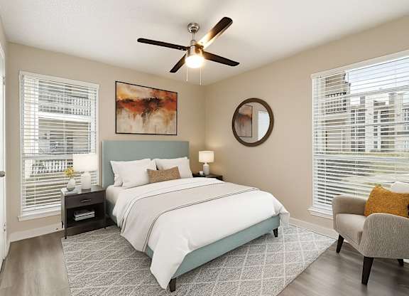 A bedroom with a large bed and a ceiling fan.