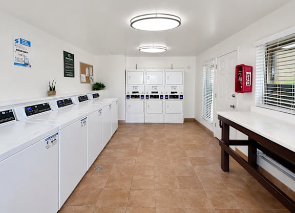 A laundromat with washers and dryers lined up on the left.