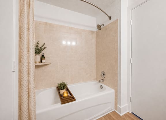 A bathroom with a white tub and a shower curtain.
