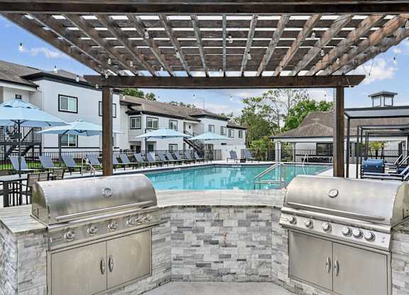 A backyard with a grill and a pool.